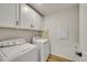 Convenient laundry room with ample cabinets and side-by-side washer and dryer at 4644 Hatcher Dr, Brighton, CO 80601