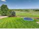 Expansive backyard featuring a vibrant green lawn and a trampoline, enclosed by a rustic wood fence at 6078 Bridle Path Ln, Parker, CO 80134