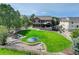 Large backyard featuring a green lawn, playset, trampoline, outdoor kitchen, patio, and mature trees at 6078 Bridle Path Ln, Parker, CO 80134