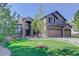 Two-story home featuring a well-manicured lawn, stone accents, and a three-car garage at 6078 Bridle Path Ln, Parker, CO 80134
