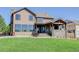 Back exterior showcasing the covered patio with stone accents, seamlessly blending indoor and outdoor living at 6078 Bridle Path Ln, Parker, CO 80134