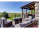 Relaxing outdoor patio with comfortable seating and fire pit, offering views of the lush backyard and open fields at 6078 Bridle Path Ln, Parker, CO 80134