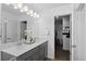 Bright bathroom featuring double sinks, gray vanity, and a large mirror with vanity lighting at 9719 Albion Ln, Thornton, CO 80229