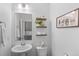 Stylish half bath with a pedestal sink, decorative shelves, and modern decor at 9719 Albion Ln, Thornton, CO 80229