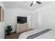 Modern bedroom featuring neutral walls, a ceiling fan, and dresser with tv at 9719 Albion Ln, Thornton, CO 80229