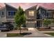 Modern townhome featuring stone accents, a single-car garage, and a manicured front yard with a young tree at 9719 Albion Ln, Thornton, CO 80229