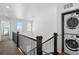 Second floor hallway features stacked washer and dryer, and access to the bedrooms at 9719 Albion Ln, Thornton, CO 80229