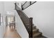 Bright hallway featuring hardwood floors, a staircase with dark wood railings, and a glimpse of the dining area at 9719 Albion Ln, Thornton, CO 80229