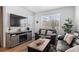 Cozy living room with stylish sofas, a modern entertainment center, and natural light from large windows at 9719 Albion Ln, Thornton, CO 80229