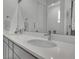Well-lit bathroom with double sinks, a large mirror, and modern fixtures at 8728 Hotchkiss St, Littleton, CO 80125