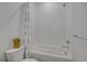 Clean bathroom featuring a tub-shower, a white floral shower curtain, and a modern toilet at 8728 Hotchkiss St, Littleton, CO 80125