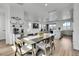 Open dining area with modern table and chairs, seamlessly connected to the living room and kitchen at 8728 Hotchkiss St, Littleton, CO 80125