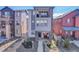 Three-story home featuring a spacious balcony with stone accents, covered porch with red chairs, and walkway at 8728 Hotchkiss St, Littleton, CO 80125