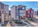 Charming three-story home featuring a spacious balcony with stone accents, covered porch, and well-maintained landscaping at 8728 Hotchkiss St, Littleton, CO 80125