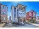 Inviting two-story home featuring a covered porch and second-story balcony with stone and blue-grey siding accents at 8728 Hotchkiss St, Littleton, CO 80125