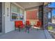 Cozy front porch featuring comfortable orange seating, a small table, and stone pillar accents at 8728 Hotchkiss St, Littleton, CO 80125