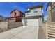 Attached garage with modern design, concrete driveway, and privacy fence in a suburban neighborhood at 8728 Hotchkiss St, Littleton, CO 80125