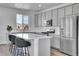 Modern kitchen features gray cabinets, stainless steel appliances, a quartz countertop island, and hardwood floors at 8728 Hotchkiss St, Littleton, CO 80125