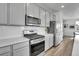 Modern kitchen features stainless steel appliances, a subway tile backsplash, quartz countertops, and gray cabinets at 8728 Hotchkiss St, Littleton, CO 80125