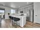 Modern kitchen features gray cabinets, stainless steel appliances, a quartz countertop island with bar stool seating at 8728 Hotchkiss St, Littleton, CO 80125