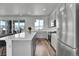 Modern kitchen featuring gray cabinets, stainless steel appliances, a quartz countertop island, and hardwood floors at 8728 Hotchkiss St, Littleton, CO 80125