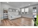 Bright living room with wood floors, large windows, and a stylish white couch for comfortable living at 8728 Hotchkiss St, Littleton, CO 80125