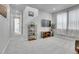 Open-concept living area with modern shelving, TV, and large windows for plenty of natural light at 8728 Hotchkiss St, Littleton, CO 80125