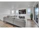 Bright living room with comfortable gray sofa, TV, lots of windows and sliding glass door to outside deck at 8728 Hotchkiss St, Littleton, CO 80125