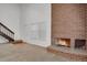 Cozy living area featuring a brick fireplace, staircase, and ample natural light at 3300 W Florida Ave # 26, Denver, CO 80219