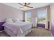 Bright bedroom with purple accent wall, ceiling fan, and double windows at 11921 S Black Horn Cir, Parker, CO 80134