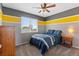 Cozy bedroom with grey walls, a yellow stripe, a comfortable bed, and natural light at 11921 S Black Horn Cir, Parker, CO 80134