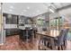 Well-lit kitchen with stainless steel appliances, dark cabinets, hardwood floors, and a dining table with decorative chairs at 11921 S Black Horn Cir, Parker, CO 80134