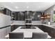 Modern kitchen featuring dark wood cabinets, stainless steel appliances, and a marble countertop island with seating at 11921 S Black Horn Cir, Parker, CO 80134