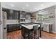 Charming kitchen with dark wood cabinets, stainless steel appliances, a marble countertop island, and a window with natural light at 11921 S Black Horn Cir, Parker, CO 80134