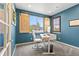 Well-lit office with blue walls, wood shutters, a modern desk, and a comfortable chair, perfect for remote work at 11921 S Black Horn Cir, Parker, CO 80134