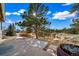 A sunny back patio has forest views and a decorative rock area at 7515 Pineridge Trl, Castle Pines, CO 80108