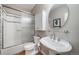 A cozy bathroom featuring a tub and shower combo with a pedestal sink and glass shelf at 7515 Pineridge Trl, Castle Pines, CO 80108