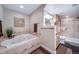 Bright bathroom featuring a jacuzzi tub with decorative tile, and a glass enclosed shower at 7515 Pineridge Trl, Castle Pines, CO 80108