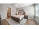 Cozy bedroom with a large bed, plush rug, ceiling fan and two bedside lamps at 7515 Pineridge Trl, Castle Pines, CO 80108