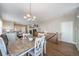 Bright dining room with hardwood floors, a chandelier, and easy access to the living area at 7515 Pineridge Trl, Castle Pines, CO 80108