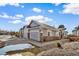 Exterior view of home featuring stone accents, well-maintained landscaping, and three garage doors at 7515 Pineridge Trl, Castle Pines, CO 80108