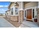 Inviting front entrance with stone accents, a bay window, and a well-lit walkway at 7515 Pineridge Trl, Castle Pines, CO 80108