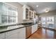 Kitchen with stainless steel appliances, white cabinetry, granite countertops, and hardwood floors at 7515 Pineridge Trl, Castle Pines, CO 80108