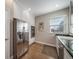 Bright kitchen with stainless steel appliances, white cabinetry, granite countertops, and hardwood floors at 7515 Pineridge Trl, Castle Pines, CO 80108