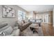 Cozy living room with a plush sofa, modern decor, hardwood floors, and natural light at 7515 Pineridge Trl, Castle Pines, CO 80108