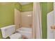 Bathroom with a standard white toilet, shower with curtain and neutral tile at 387 Upham St, Lakewood, CO 80226