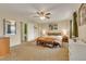 Bright bedroom features a bed with an orange blanket, neutral carpet, and a ceiling fan at 387 Upham St, Lakewood, CO 80226