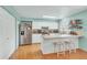 Bright kitchen featuring white cabinets, stainless steel appliances, and wood floors at 387 Upham St, Lakewood, CO 80226