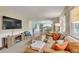 Cozy living room with comfortable seating, a stone fireplace, and view to the kitchen and dining area at 387 Upham St, Lakewood, CO 80226