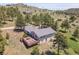 Aerial view of home with expansive land, trees, and a large deck with outdoor furniture at 258 Post Boy Rd, Boulder, CO 80302